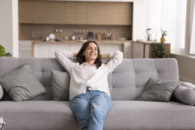 Tasasız bir hafta sonu. Mutlu, genç, güzel bir kadın, şık stüdyo dairesinin yumuşak kanepesinde tek başına rahatlayıp huzurlu, stressiz, kendi ev atmosferinde güzel müzik dinlemenin keyfini çıkartıyor.