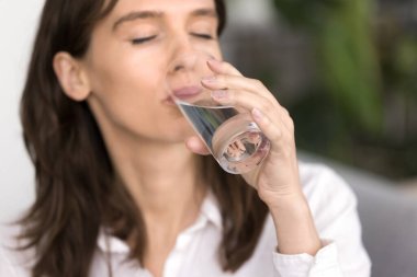 Bardakta saf zevk. Kapalı portre susuz kalmış bin yıllık kadın susuzluğunu hissediyor taze, temiz, doğal maden suyu içiyor. Günlük güzellik hizmetleri hidrasyon sağIıklı yaşam tarzı konsepti
