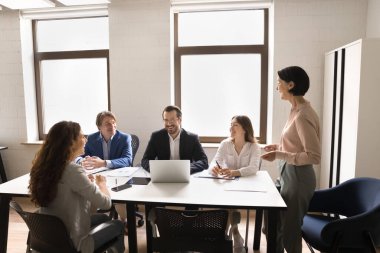Stratejik planlama brifingi. Gülümseyen olgun kadın iş lideri şirket CEO 'su iş eğitimi semineri yönetim kurulu toplantısında çeşitli motivasyonlu ofis ekibine yeni proje sunuyor.