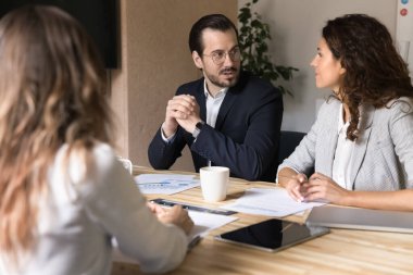 Uzmanlığımızı paylaşıyoruz. Resmi takım elbiseli, kendinden emin orta yaşlı işadamı toplantı masasındaki çeşitli iş arkadaşlarıyla konuşuyor. Fikir üretme stratejisi önerisi sunuyor. Sorunlara çözüm öneriyor.