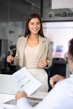 Meslektaşlarına, ortaklarına, sunum toplantısında yatırımcılara iş planı sunan, personelle konuşan, kağıt pazarlama raporlarını açıklayan genç, pozitif bir proje yöneticisi. Dikey çekim