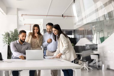 Çok ırklı iş adamlarından oluşan bir ekip dizüstü bilgisayarda bir araya gelip online sunum ve içerik izliyorlar. Afrikalı Amerikalı yazılım mühendisi çeşitli iş arkadaşlarına yeni uygulama gösteriyor