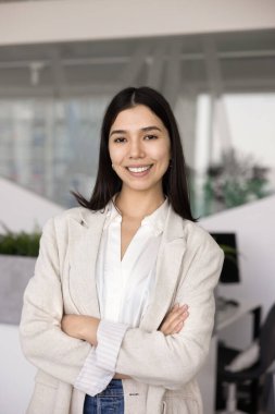 Kendine güvenen Ortadoğulu iş adamları güven jesti yaparak kollarını kavuşturuyor, kameraya gülümsüyor, dikey kafaya poz veriyor. Mutlu Asyalı genç iş adamının portresi