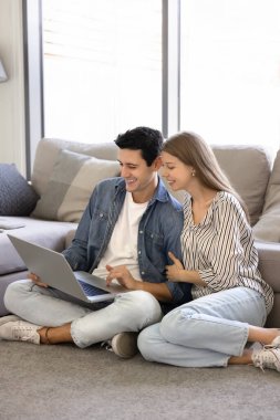 Genç ve güzel bir çift internette boş vakitlerini birlikte geçirir dizüstü bilgisayarla birlikte oturur, sipariş verir veya video görüşmesi yapar, çevrimiçi içeriği izler, web sörfü bilgisi izler, yeni eğlenceli platformları gözden geçirir. E-alışveriş