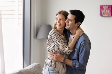 Modern oturma odasında birbirine aşık mutlu genç bir çift, kucaklaşıyorlar, neşeli bir ifadeyle pencereden dışarı bakıyorlar, hayal kuruyorlar, romantik randevulardan ve yakınlık anlarından zevk alıyorlar. İlişkiler