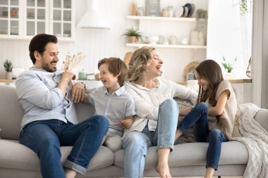 Hafta sonu evde neşe. Sevecen, sevecen anne baba, eğlenceli gıdıklama oyunu oynuyor. Aktif küçük çocuklarla, çeşitli kardeşlerle kanepede eğleniyor. İçeride kahkahalar atıyor.