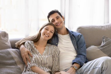 İspanyol bir adam ve Arjantinli bir kadının portresi. Evdeki rahat koltukta oturup birlikte vakit geçiriyorlar. Oturma odasında dinleniyorlar. İlişki, refah, sevgi dolu çift fotoğrafı.