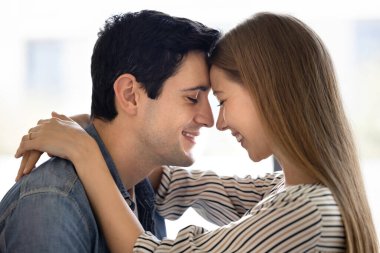 Kapalı alanlarda kucaklaşan, alınlarına nazikçe dokunan, gözleri kapalı gülümseyen, hassas anın tadını çıkaran, aşkı hisseden, derin bir bağ kuran genç çiftin yakın fotoğrafını çek. İlişkiler