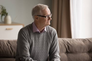 Odaklanmış zihin. Ciddi bir portre. Gözlüklü, düşünceli, olgun bir adam. Oturma odasındaki koltukta oturup gelecekteki hedefleri planlamaya odaklanmış.