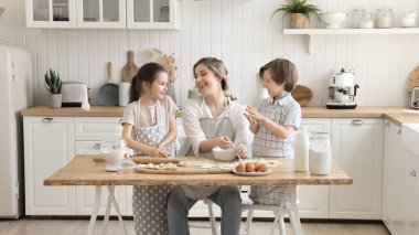 Sevimli küçük şefler. Gülen küçük çocuklar, önlüklü abla küçük kardeş anne lezzetli hamur işlerinde yardımcı oluyor yumuşak çiğ hamurla çalışmanın keyfini çıkarıyor aile kahvaltısını hazırlamaya yardım etmekten gurur duyuyorum.