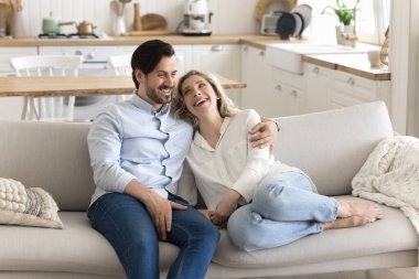 İlişkide uyum. Mutlu orta yaşlı evli çift evde huzurlu bir anın tadını çıkarın. Mutfaktaki rahat koltukta rahatlayın. Sıcak sohbetler, rüyalar, hoş sohbetler.