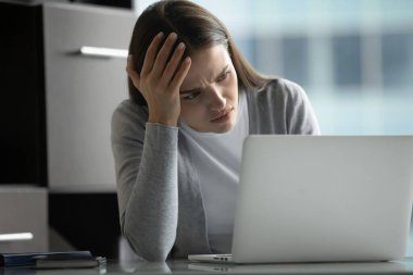 Dijital sorun. Sinirli genç iş kadını proje yöneticisi dizüstü bilgisayara baktığında stresli hissediyor. Dolandırıcılık e-postası alıyor. Bilgisayar hatası zor problemi çözemiyor.