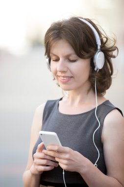 Smiling female choosing song on device