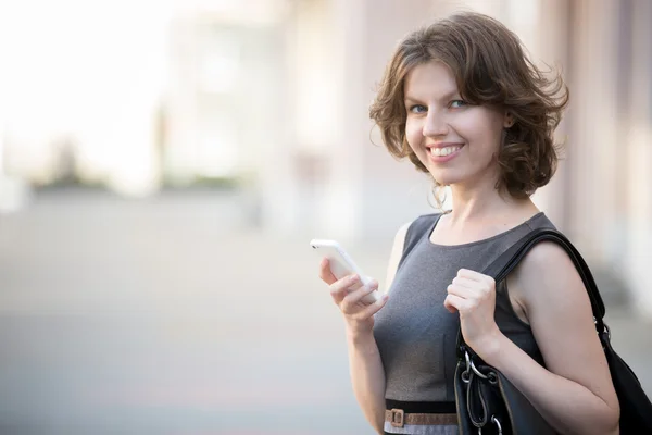 Young woman messaging on the street — Stockfoto