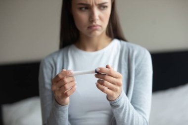 Beklenmedik sonuç endişesi. Hızlı doğurganlık testinden memnun kalmayan üzgün genç bir kadın. Planlanmamış hamilelik emniyetsiz doğum kontrolü başarısız oldu. Yakından kesilmiş.