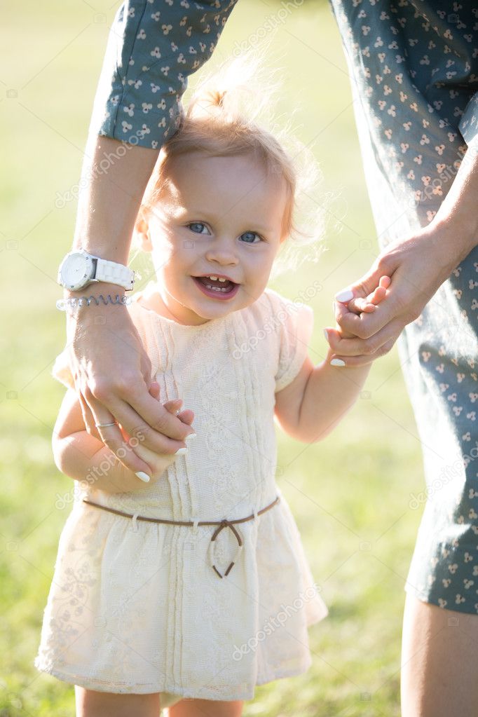 Mom teaching tot daughter to walk