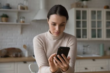 Odaklanmış akıllı telefon kullanıcısı kız sosyal medyada sohbet ediyor, cep telefonunu tutuyor, mesaj yazıyor, internleri karıştırıyor. Çevrimiçi uygulama kullanan genç bir kadın, cep telefonunda servis