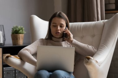 Ciddi odaklı uzaktan kumandalı çalışan, cep telefonuyla konuşan, dizüstü bilgisayar kullanan, evde çalışan, koltukta oturan, alet tutan. Serbest çalışan, telefon görüşmesi yapan danışman.