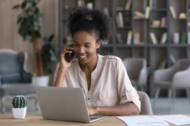 Mutlu genç Zenci uzaktan çalışan, cep telefonuyla konuşan, evden çalışan bir işçi. Milenyum analisti, girişimci, gen Z kızı dizüstü bilgisayardaki müşteriye cevap veriyor, müşteriye danışmanlık yapıyor.
