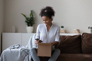 Mutlu Afrikalı müşteri gönderme için paket hazırlama, paketleme, akıllı telefon kullanma, kurye teslimat posta servisi sipariş etme. Alıcı paket alıyor, cep telefonundan geri bildirim veriyor