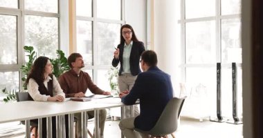 Yetişkin iş kadını lideri resmi toplantıda konuşuyor, proje açıklaması yapıyor, konferans masasında onu dinleyen iş adamlarına strateji paylaşıyor. Bilgilendirme ya da eğitim, ofiste iletişim