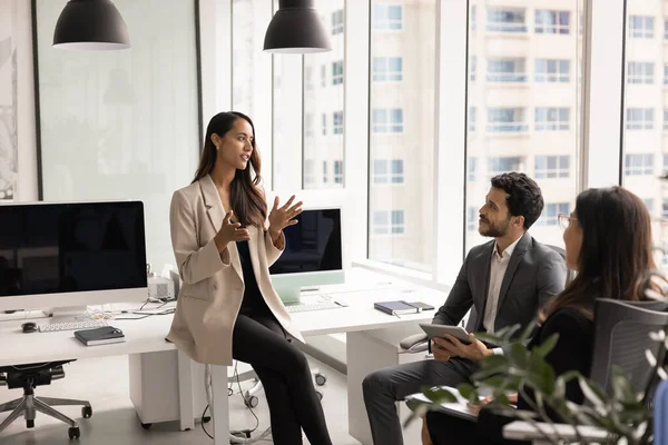 Kendine güvenen kadın proje yöneticisi sunum yapıyor, çözümü açıklıyor, yeni strateji, modern iş ortaklığında toplantı veya beyin fırtınası sırasında takım arkadaşlarıyla proje planını tartışıyor