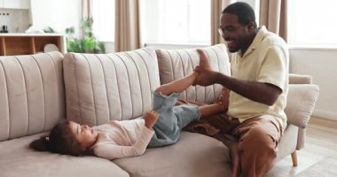 Kara Baba 'yı evde kızıyla oynarken sevmek, anaokulu çocuğunu kanepeye yatırıp gıdıklamak, onu güldürmek, oturma odasında kaygısızca eğlenmek. Aile bağı, sevgi, babalık.