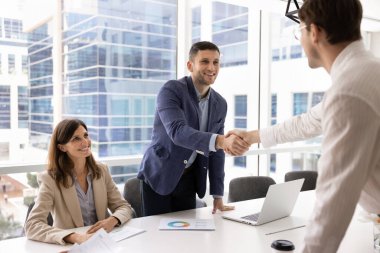 İki pozitif işadamı, ticari anlaşma yapan profesyoneller, konferans masasında el sıkışma jestiyle iş ortaklığını sonuçlandırdılar. Anlaşma, başarılı pazarlıklar