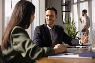 Kendine güvenen yakışıklı iş adamı, iş yerinde bayan meslektaşıyla konuşuyor, takım çalışması, işbirliği, profesyonel tavsiyeler, danışmanlık...