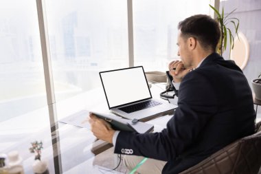 Formalite içinde düşünceli bir iş adamı defterdeki notlar üzerinde düşünür, bilgisayarın başında boş bir ekranla oturur, çeneye dokunur, iş programı planlar, görevler...