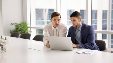 Dizüstü bilgisayarla sunum üzerinde çalışan, iş belgesini düzenleyen, pazar eğilimlerini araştıran, proje için bir sonraki adımı planlayan, satış sonuçlarını değerlendiren iki odaklı Avrupalı şirket çalışanı