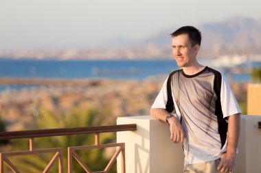 Young man on the terrace in sunlight