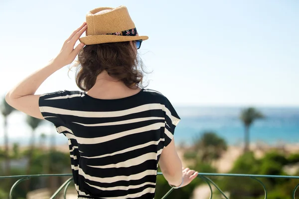 Giovane donna che guarda il mare dal balcone — Foto Stock