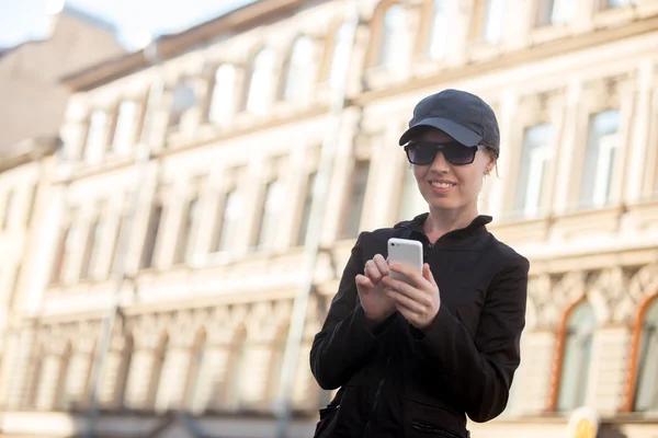 Ung kvinna messaging på gatan — Stockfoto