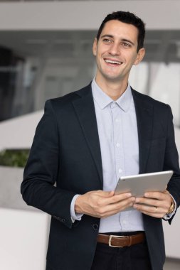 Dikey görüntü gülümseyen İspanyol iş adamı uzman satış temsilcisi elinde tabletle olumlu pazarlamanın tadını çıkarıyor dijital verimlilik girişimi başarısı