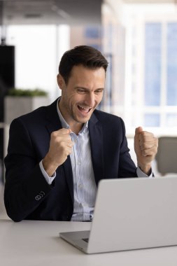 İspanyol erkek girişimci iş başarısını kutluyor kariyer tanıtım e-postalarını okuyor harika iş sonuçları alıyor proje onayı alıyor veya ofis masasında bilgisayardan profesyonel zafer haberleri alıyor