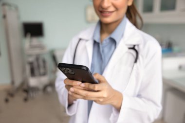 İş yerinde akıllı telefon kullanan, telefon görüşmeleri, video sohbetleri ya da profesyonel platformlar yoluyla iş arkadaşlarıyla görüşen, randevuları tıbbi programlama uygulamaları aracılığıyla yöneten kadın doktorların yakın planlanmış görüntüleri