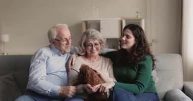 Çok nesilli aile, kaniş köpeğiyle evde vakit geçirmenin tadını çıkarıyor. Emekli çift ve kızları ya da torunları oturma odasında kanepede oturup konuşuyorlar, evde vakit geçiriyorlar. Nesiller arası bağ