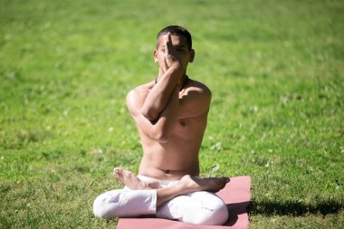 Lotus Pose with Eagle Arms in park