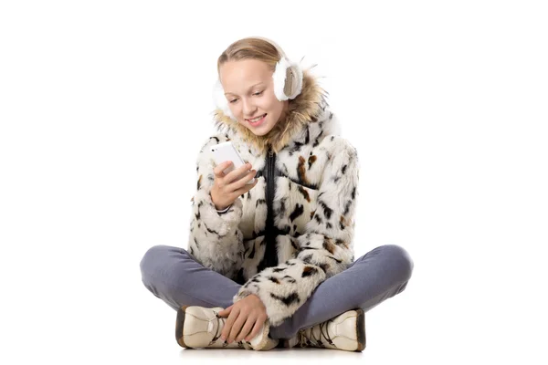 Chica feliz en traje de invierno usando el teléfono móvil —  Fotos de Stock