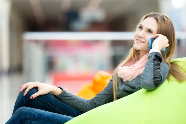 Feliz chica adolescente sentada en la silla beanbag en inte contemporáneo — Foto de Stock