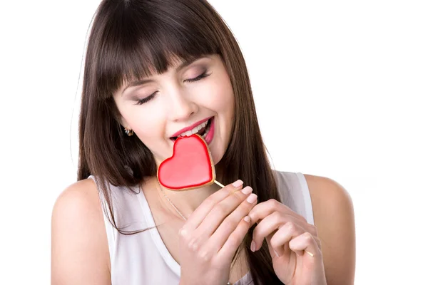 Mulher feliz comer biscoito em forma de coração — Fotografia de Stock