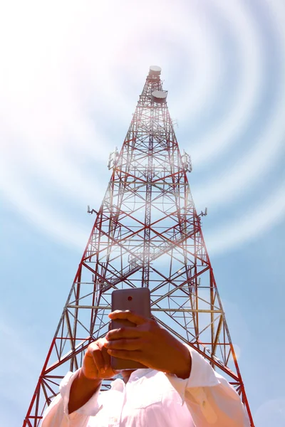 Femme avec smartphone près de la tour de télécommunication — Photo