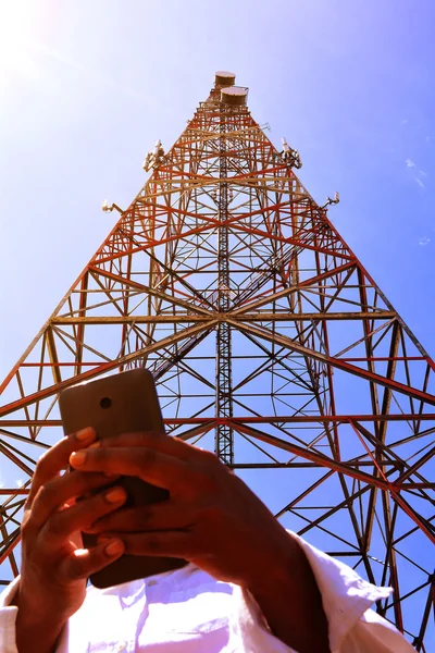 Nő, smartphone, távközlési torony közelében — Stock Fotó