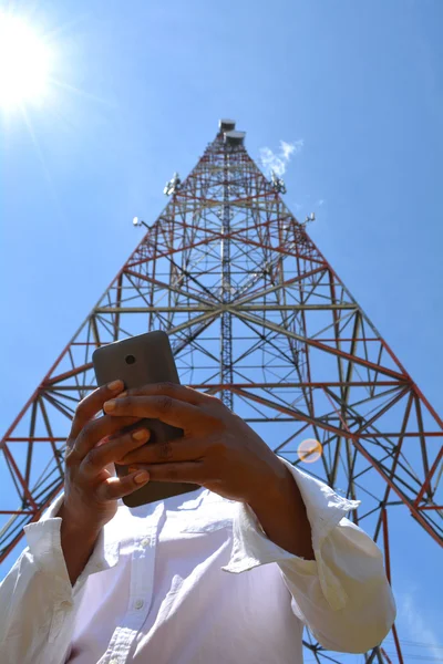 Kobieta z smartfon w pobliżu Wieża radiowo-telewizyjna — Zdjęcie stockowe