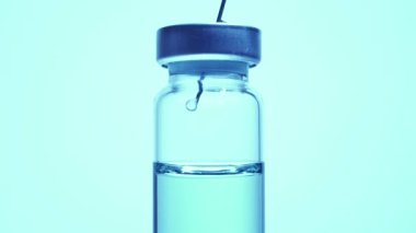 Tıp aşısı bilim adamı Coronavirus, COVID-19, MERS, 2019-ncov 'a karşı aşı araştırmaları üzerinde çalışıyor ve geliştiriyor. Cam şişedeki mavi sıvıyı iğneyle karıştırıyorum. Değerlendirme ve denemeler.