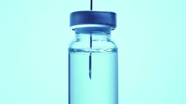 Şırıngayı şişeden aşıyla dolduruyorum. Aşırı makrodan. Steril tıbbi iğne şırıngası ve tıbbi klinikteki hasta aşısı için mavi koronavirüs aşısı ile ilaç veriliyor..