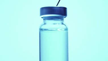 Şırıngayı şişeden aşıyla dolduruyorum. Aşırı makrodan. Steril tıbbi iğne şırıngası ve tıbbi klinikteki hasta aşısı için mavi koronavirüs aşısı ile ilaç veriliyor..