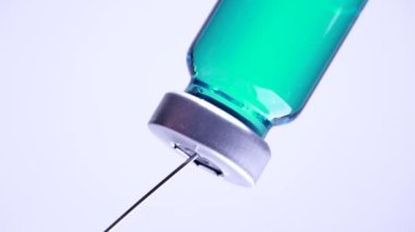 Şırıngayı şişeden çıkan aşıyla dolduruyorum. Tıbbi iğne şırıngası ve hasta aşısı için şırınga ve aşı tedavisi uyguluyor. Sağlık ve tıbbi kavramlar.