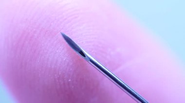 Parmak şırıngaya değiyor. Makro, kapat. Trypanofobi, enjeksiyon ya da enjeksiyon korkusu. Keskin iğneye tehlikeli bir şekilde yakın deri. Fobiler ve travmalar.